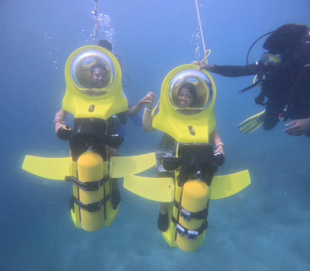 Guests riding underwater scooters with an accompanying diver